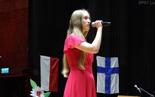 Uczennica śpiewa na scenie do mikrofonu